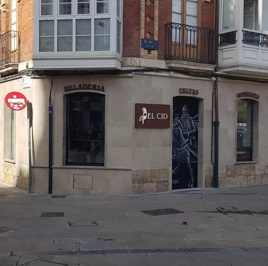 La esquina de El Cid en Plaza Vega: heladería, trufas y bombones, con el mural del Cid a caballo en la persiana